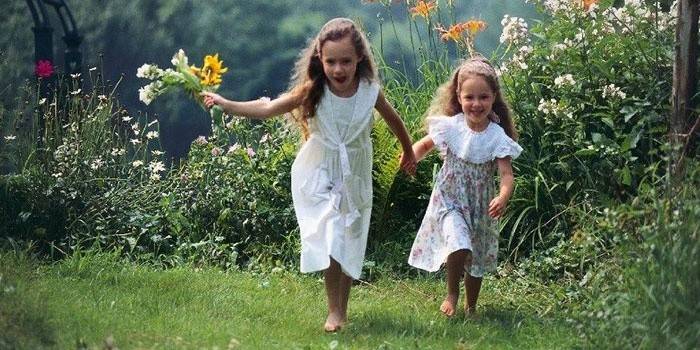 Девочки бегают босиком по траве