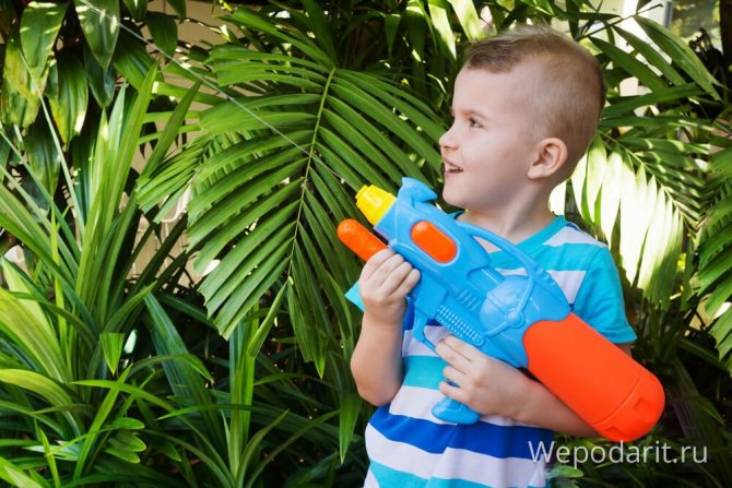 мальчик играется с водяным пистолетом