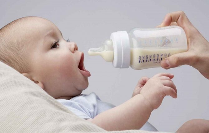 младенца кормят из бутылочки