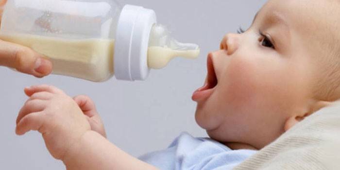 Baby is fed formula from a bottle