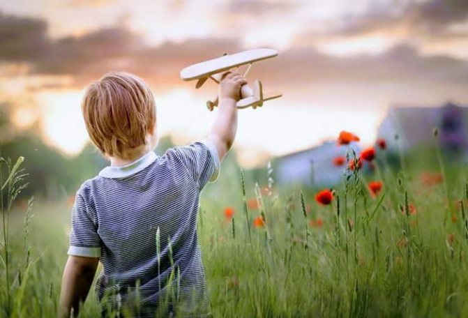 Child playing with a wooden plane