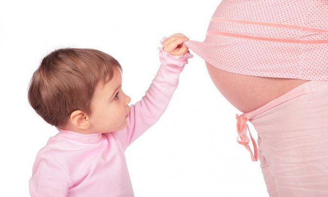 ребенок смотрит на живот беременной